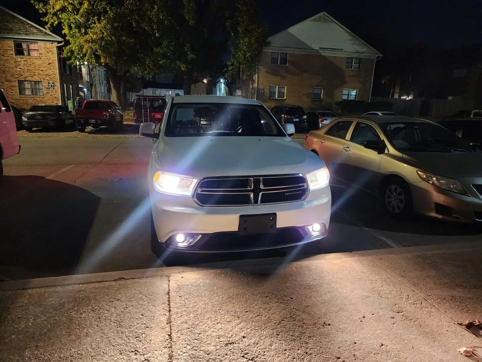 Vehicle waiting on a lit street at night.